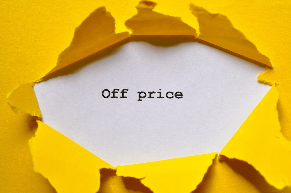 A close-up photograph shows a torn piece of bright yellow paper with irregular, jagged edges, revealing a white paper underneath. On the white surface, the phrase 'Off price' is printed in black typew